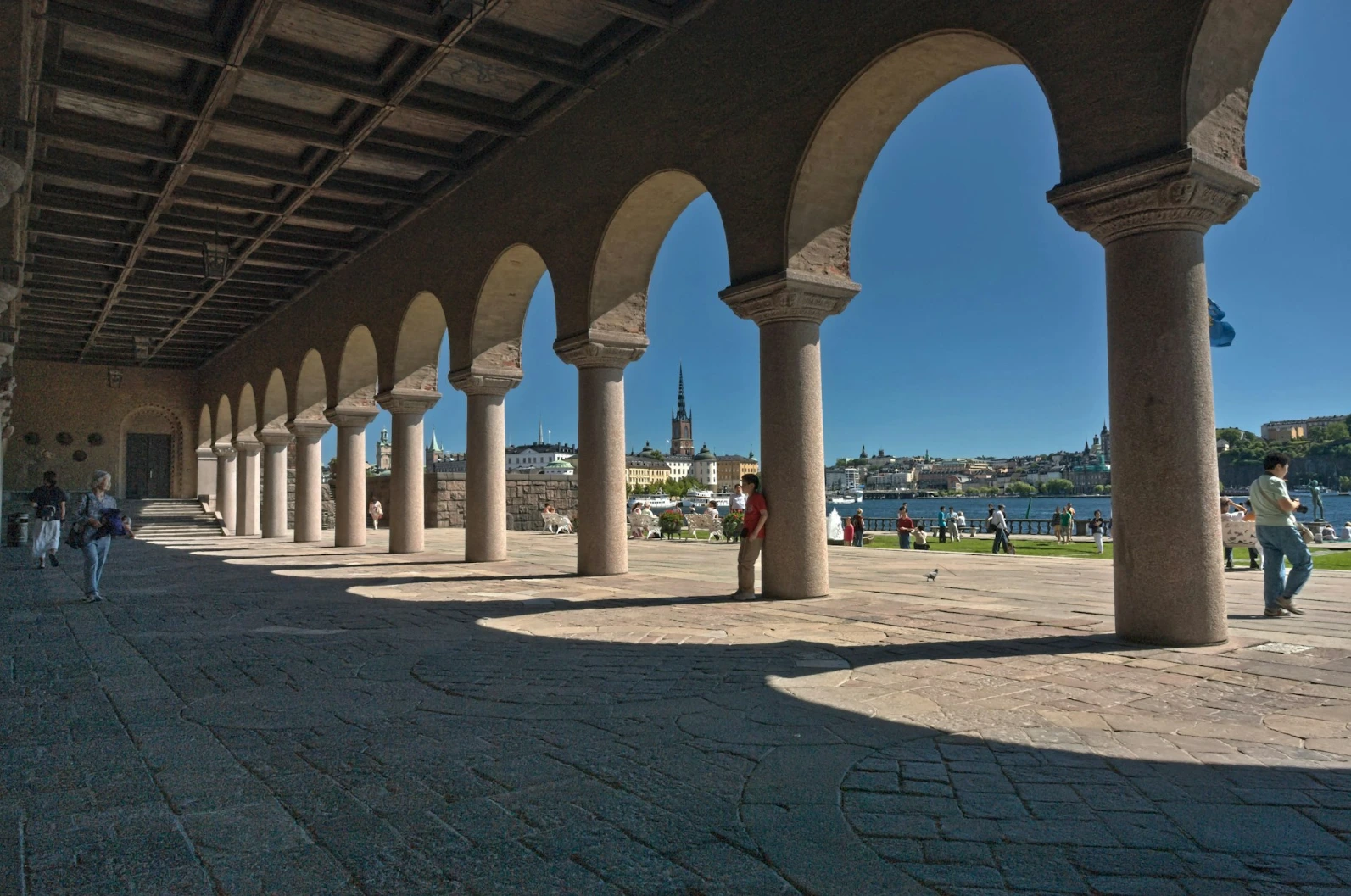 Arched colonnade with distant city skyline and people